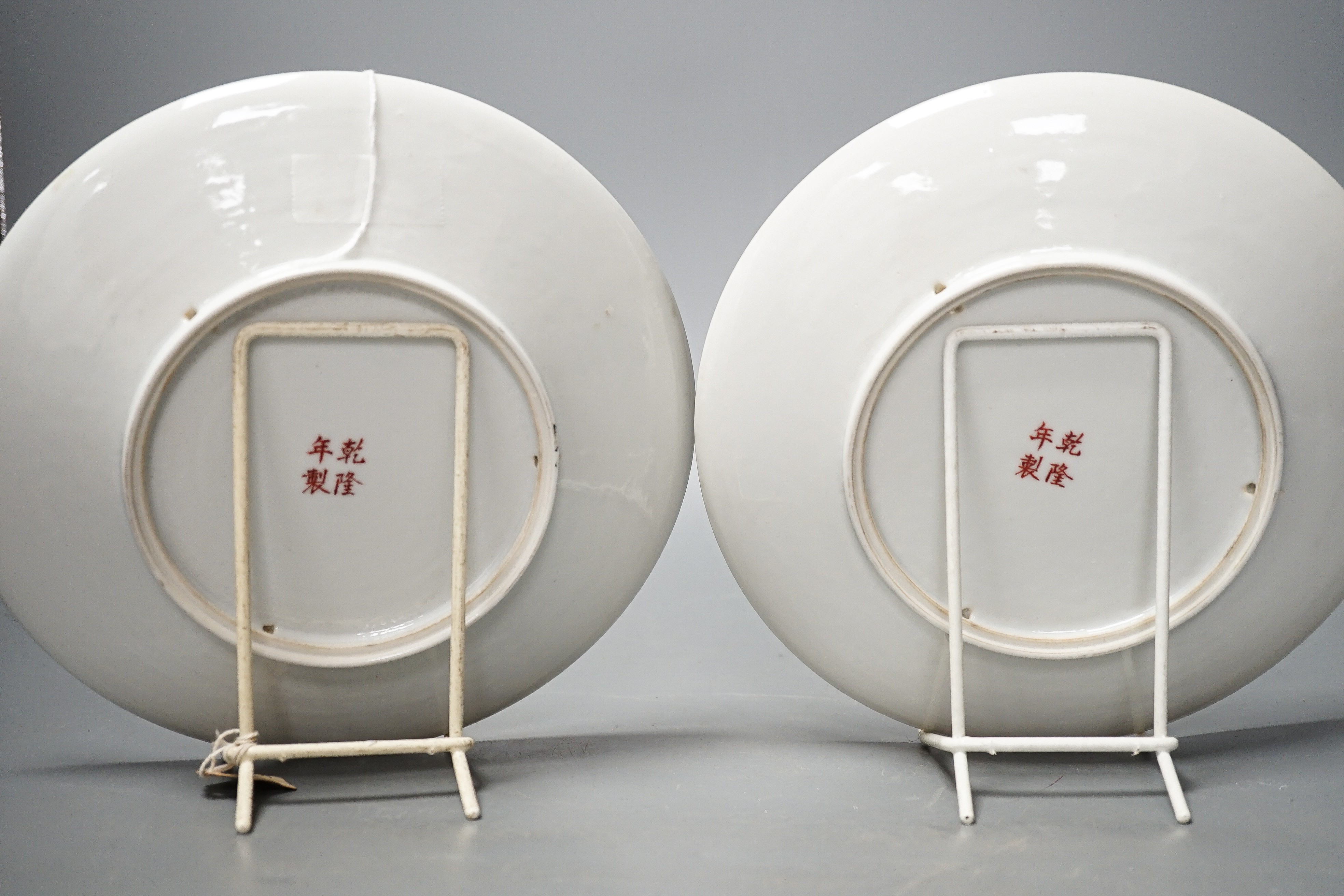 A pair of Chinese famille rose dishes, Qianlong marks possibly Republic period, each painted with a bird perched amid prunus and bamboo or red blossom and peonies, inscribed, D. 22cm